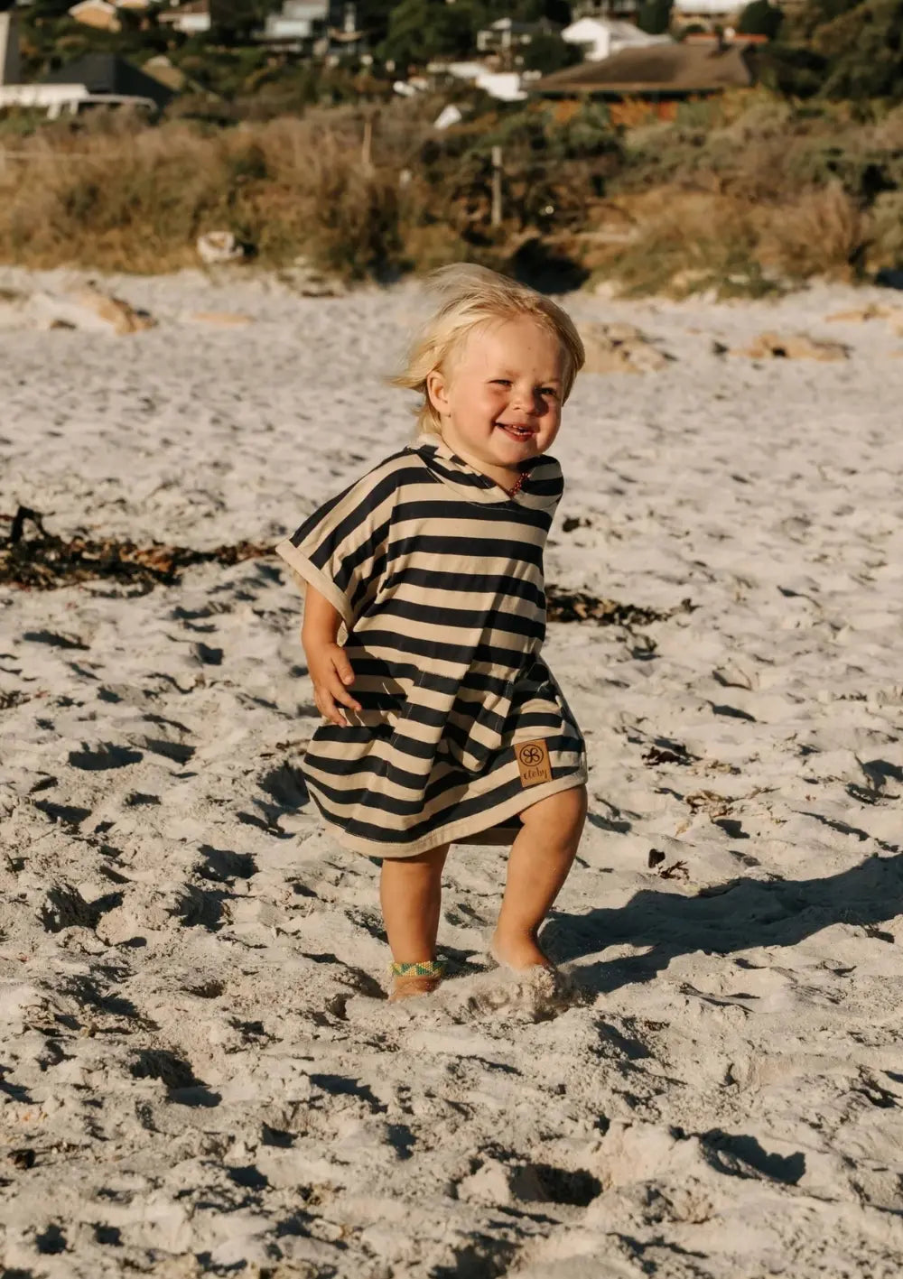 Junge trägt Cloby UV-Poncho UPF 50+ Navy Stripe am Strand