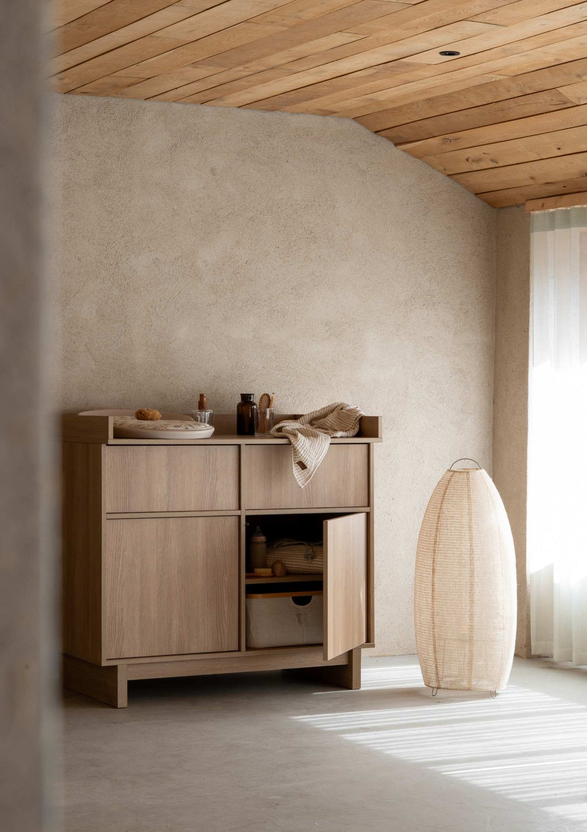 Quax (Wickel-)Kommode 'Kyo' Honey Ash mit Wickelkissen und Alltagsutensilien und Aufbewahrungskorb im Fach