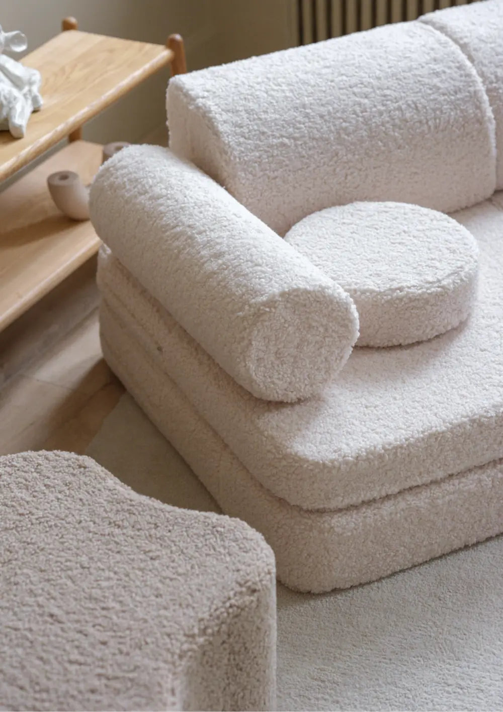 Nahaufnahme der Armlehne und Sitzfläche des cremeweißen modularen Wigiwama Kindersofas Teddy Cream White aus flauschigem Plüsch.